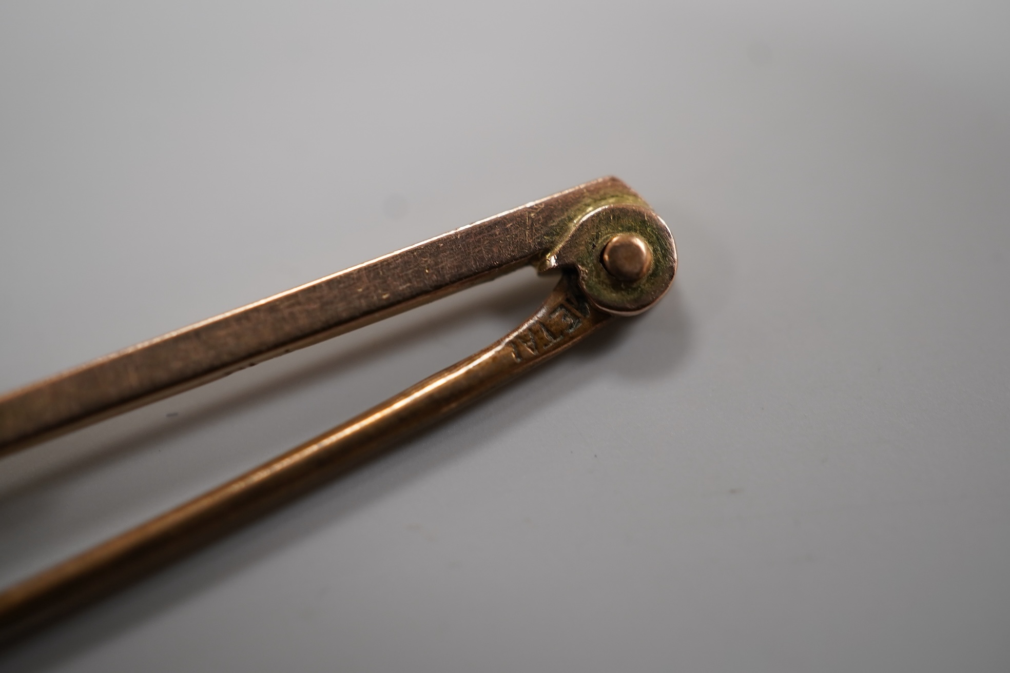A cased early 20th century 9ct and single stone split pearl set bar brooch, 42mm and a white metal coin bracelet.